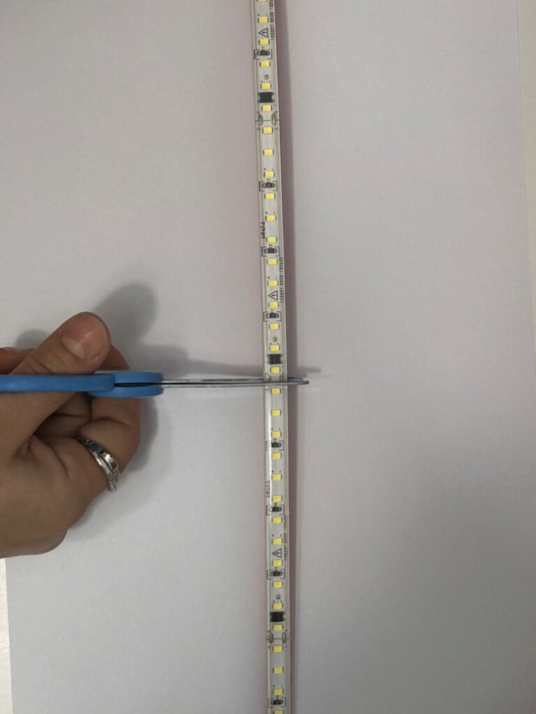 Couper un ruban LED avec des ciseaux sur la zone de découpe